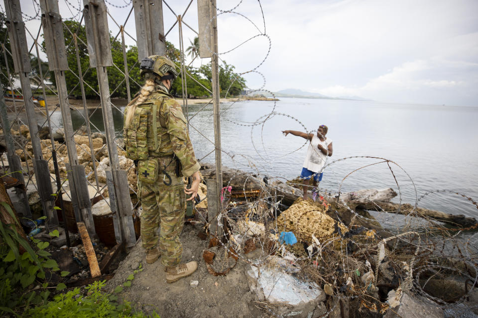 An Australian Army soldier talking with a local fisherman at Guadalcanal Port, Solomon Islands, on 30 November 2021. Source: AAP/Department of Defence