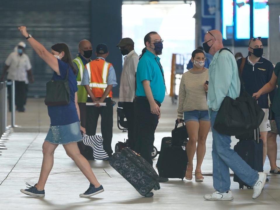 volunteer employees for Royal Caribbean's Freedom of the Seas Sailing walking and holding luggage