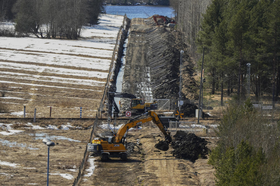 Excavators work at a construction site of the border barrier fence between Finland, right, and Russia near Pelkola border crossing point in Imatra, south-eastern Finland, Friday, April 14, 2023. (AP Photo/Sergei Grits)