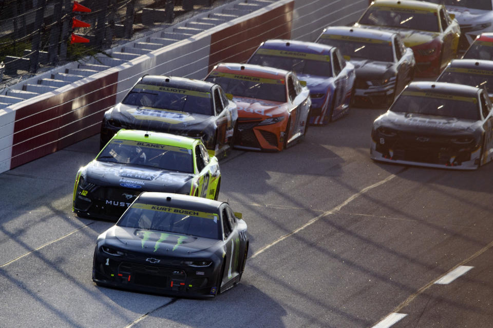 Kurt Busch (1) leads Ryan Blaney (12) after the first yellow flag during a NASCAR Cup Series auto race Sunday, Sept. 5, 2021, in Darlington, S.C. (AP Photo/John Amis)