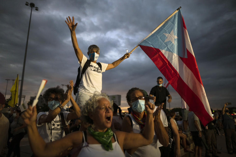 People march along Las Americas Highway to protest the LUMA Energy company in San Juan, Puerto Rico, Friday, Oct. 15, 2021. Ever since LUMA began providing service over the summer, hundreds of thousands of Puerto Ricans have had to deal with widespread blackouts for extended periods of time, voltage fluctuations and bad customer service along with an increase in pricing. (AP Photo/Carlos Giusti)