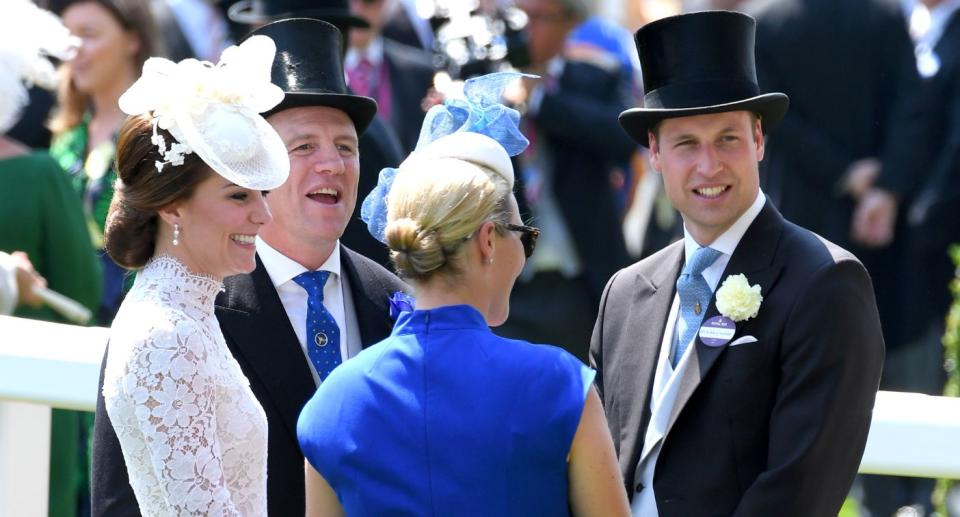 Kate Middleton laughs while wearing a white lace dress. She is speaking to Zara and Mike Tindall and her husband, Prince William. (Getty Images)