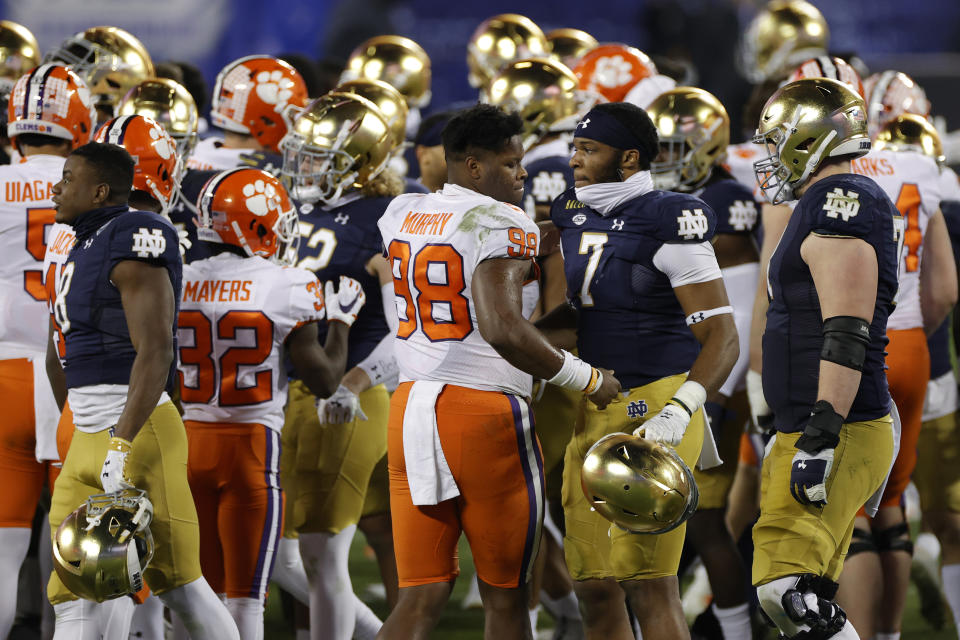 CHARLOTTE, NORTH CAROLINA - DECEMBER 19: Clemson Tigers players greet Notre Dame Fighting Irish players after the ACC Championship game at Bank of America Stadium on December 19, 2020 in Charlotte, North Carolina. The Clemson Tigers defeated the Notre Dame Fighting Irish 34-10. (Photo by Jared C. Tilton/Getty Images)