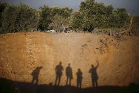 Photographers take pictures at the scene of an Israeli air strike in Gaza City October 11, 2015. REUTERS/Suhaib Salem