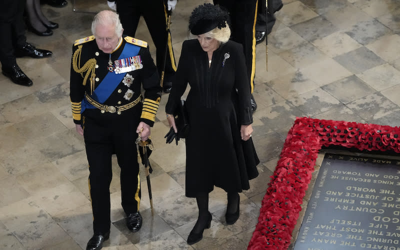 King Charles III, left, and Camilla follow the coffin of Queen Elizabeth II as it is carried.