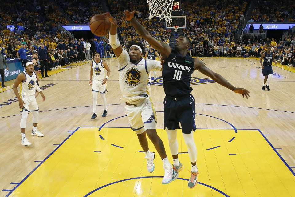 Golden State Warriors center Kevon Looney (5) defends against a shot by Dallas Mavericks forward Dorian Finney-Smith (10) during the second half of Game 2 of the NBA basketball playoffs Western Conference finals in San Francisco, Friday, May 20, 2022. (AP Photo/Jed Jacobsohn)