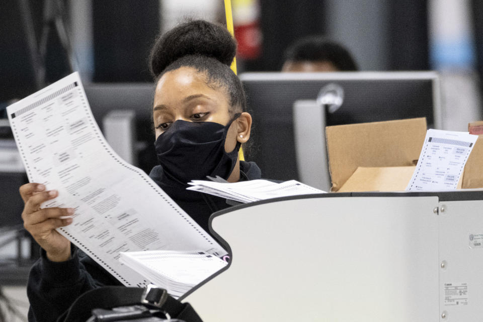 A worker scans ballots as the presidential recount process gets under way Tuesday afternoon, Nov. 24, 2020 in the DeKalb County, Ga. (AP Photo/Ben Gray)