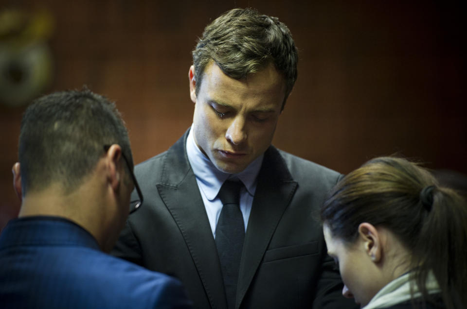 FILE - In this Monday, Aug. 19, 2013 file photo, Oscar Pistorius cries as he prays with his sister Aimee and brother Carl in the magistrates court in Pretoria, South Africa. Pistorius was indicted Monday on charges of murder and illegal possession of ammunition for the shooting death of his girlfriend Reeva Steenkamp. It was reported on Thursday, Jan. 23, 2014, that Oscar Pistorius' lawyers have been negotiating an out-of court settlement for nearly six months with representatives of the parents of slain girlfriend Reeva Steenkamp, which a legal expert says could be raised by prosecutors in the Olympic athlete's murder trial. Lawyers for both sides said Thursday the negotiations are continuing and declined to comment on any details of a possible settlement, which media reports say could see the double-amputee runner pay in the region of $275,000 to Steenkamp's family. (AP Photo, File)