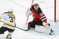 New Jersey Devils goaltender Mackenzie Blackwood (29) makes a glove save with Boston Bruins center Patrice Bergeron (37) threatening in front of the crease during the first period of an NHL hockey game, Tuesday, May 4, 2021, in Newark, N.J. (AP Photo/Kathy Willens)