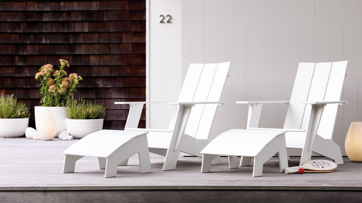  A pair of white Adirondack chairs outside a contemporary building 