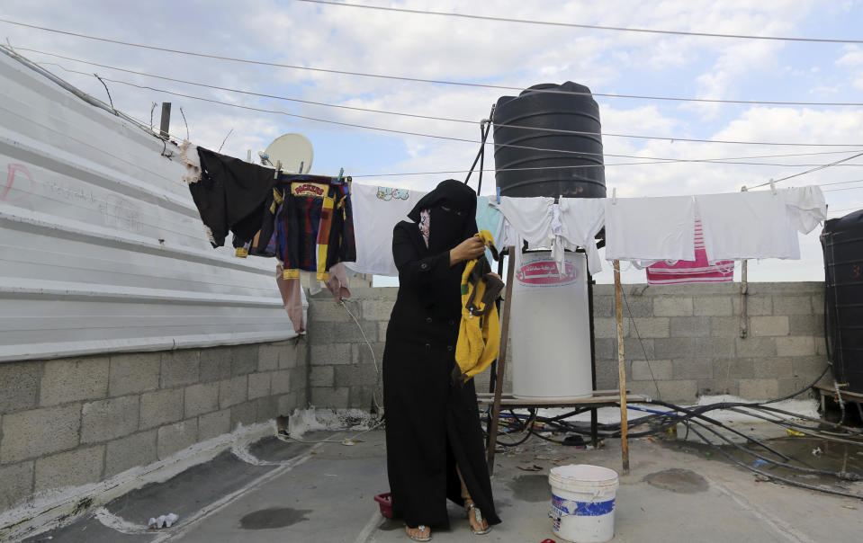 In this Tuesday, March 11, 2014 photo, Minatullah Zeitouniya, 29, hangs laundry to dry on the roof of the apartment building she and her family live in Gaza City in the northern Gaza Strip. Gaza's Hamas rulers have been hit by the worst economic crisis since seizing the territory seven years ago and face growing discontent, even among core supporters, because there's no sign of relief from a blockade enforced not only by Israel but also by a suddenly hostile Egypt. (AP Photo/Hatem Moussa)