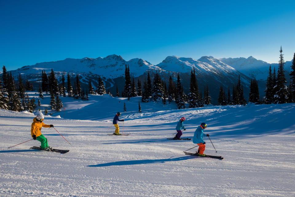 Couples skiing together on a sunny day./Getty Images