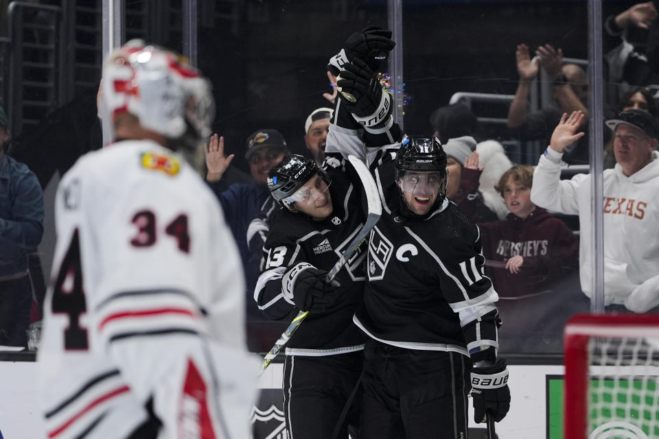Los Angeles Kings center Anze Kopitar, right, celebrates his goal against Chicago Blackhawks goaltender Petr Mrazek with defenseman Jacob Moverare during the second period of an NHL hockey game, Tuesday, March 19, 2024, in Los Angeles. (AP Photo/Ryan Sun)