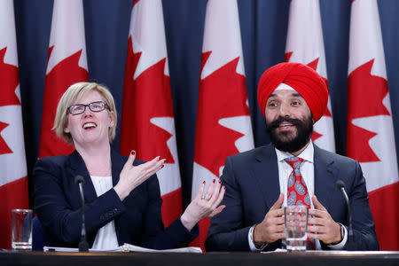 Canada's Public Works Minister Carla Qualtrough (L) and Innovation Minister Navdeep Bains react during a news conference in Ottawa, Ontario, Canada, December 12, 2017. REUTERS/Chris Wattie