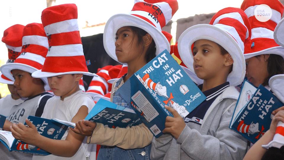 Children sport the famous "Cat in the Hat" headwear as they line up on Read Across America Day, which in 2021 omitted Dr. Seuss titles amid controversy over racist content. Six titles were pulled by Dr. Seuss Enterprises. Seuss books returned to Read Across America Day this year.