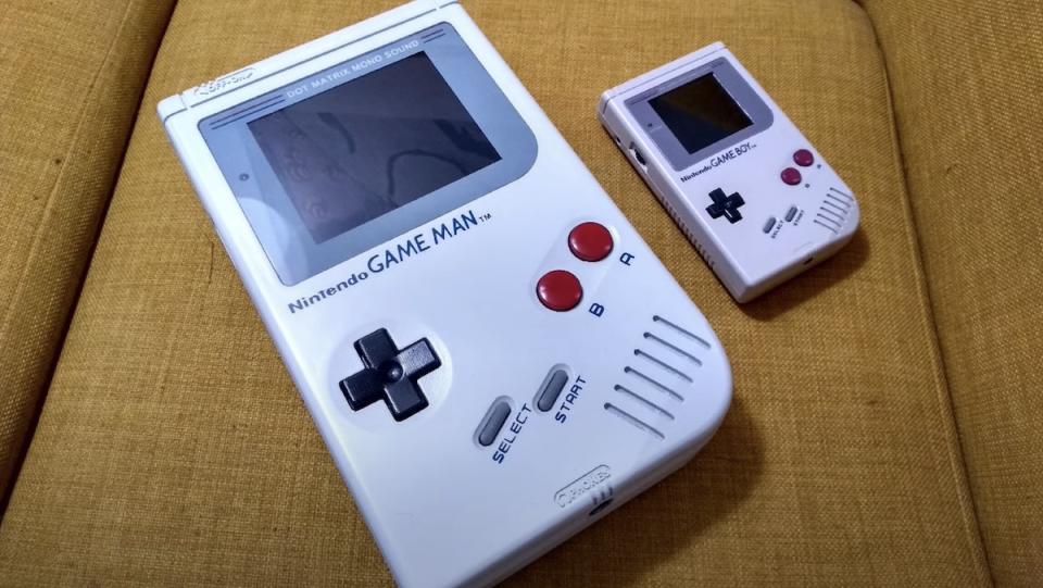 A giant fan-made version of the Nintendo Game Boy resting next to an original version