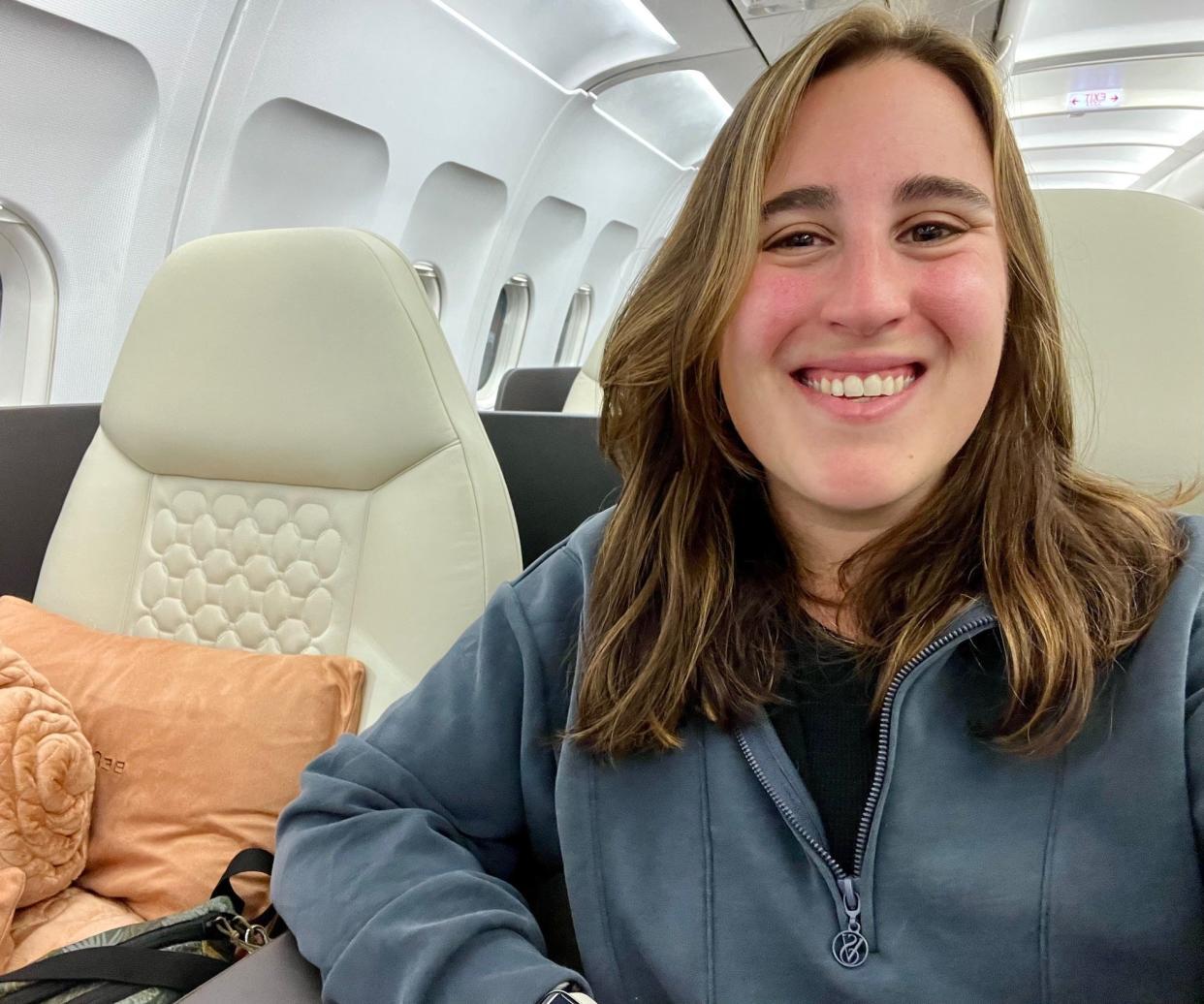 The author in a navy sweatshirt sitting the Beond aisle seat.