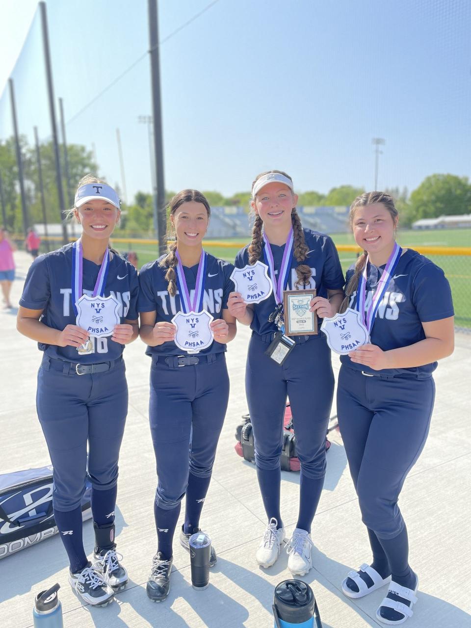 Emma Bello, Anna Bello, tournament MVP Maddy Throumoulos and Maddie Hicks show off their patches after leading Webster Thomas to their first Section V title since 2009.