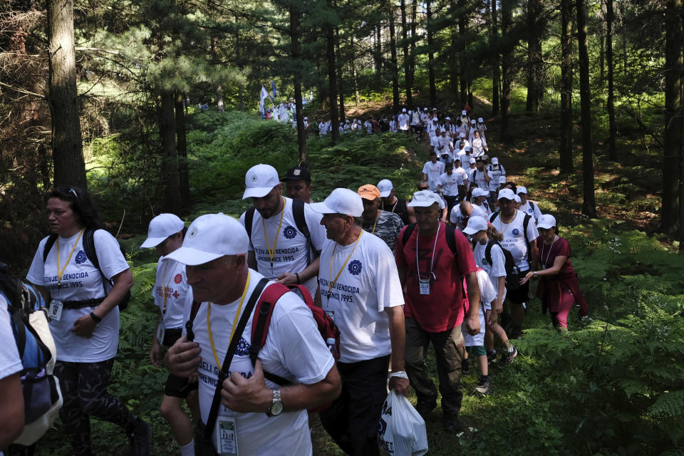 FILE - In this July 8, 2021, file photo, participants, some of them survivors of the 1995 Srebrenica massacre, walk through a mountain area near Nezuk, Bosnia, during a Peace March recreating the path taken 26 years ago by people trying to escape the advancing Bosnian Serb forces. Twenty-six years after the July 1995 Srebrenica massacre, the only episode of Bosnia’s 1992-95 war to be legally defined as genocide, its survivors continue to grapple with the horrors they endured while also confronting increasingly aggressive downplaying and even denial of their ordeal. (AP Photo/Kemal Softic, File)