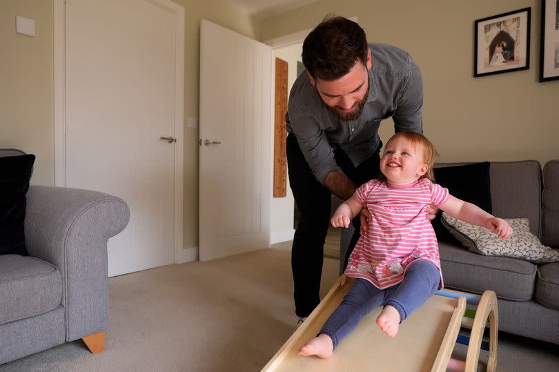 Opal Sandy plays with her father James