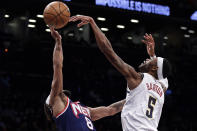 Denver Nuggets forward Will Barton (5) blocks a shot by Brooklyn Nets guard Patty Mills during the second half of an NBA basketball game Wednesday, Jan. 26, 2022, in New York. The Nuggets won 124-118. (AP Photo/Adam Hunger)
