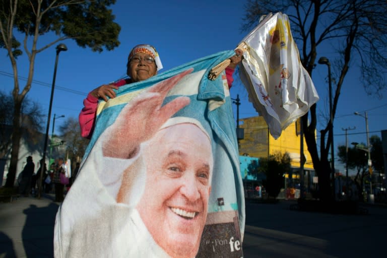 A woman shows a blanket with the image of Pope Francis in the streets of Mexico City on February 13, 2016