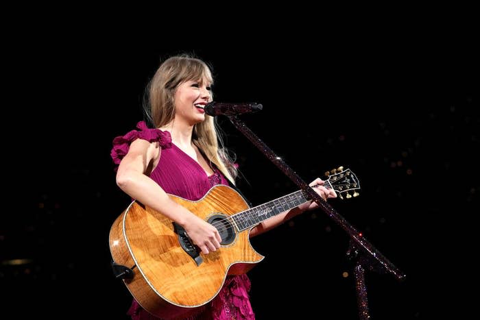 taylor playing guitar on stage