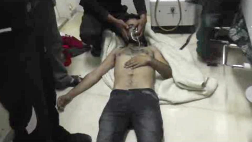 In this Friday, April 11, 2014 image made from amateur video provided by the Shams News Network, a loosely organized anti-Assad group based in and out of Syria that claim not to have any connection to Syrian opposition parties or any other states, and which is consistent with independent AP reporting, a man lies on the floor with an oxygen mask at a hospital room in Kfar Zeita, some 200 kilometers (125 miles) north of Damascus, Syria. Syrian government media and rebel forces said Saturday, April 12, 2014 that poison gas had been used in the village, on Friday injuring scores of people, while blaming each other for the attack. (AP Photo/Shams News Network)