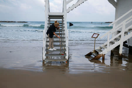 A woman cleans the stairs of a lifeguard tower before the winners of an international online competition arrive to spend a night at the tower which was renovated into a luxury hotel suite, at Frishman Beach in Tel Aviv, Israel March 14, 2017. REUTERS/Baz Ratner