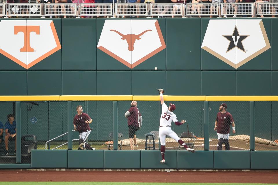 In front of a backdrop of Tennessee, Texas and Vanderbilt banners, Mississippi State outfielder Brad Cumbest leaps against the fence to reach for a Vandy home run during last year's College World Series. Mississippi State went on to win the national championship.