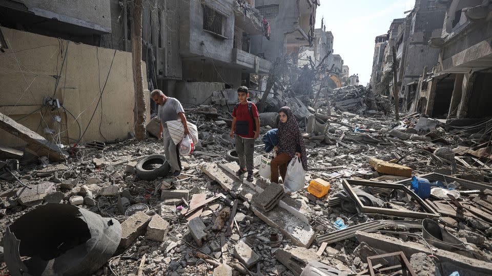 Palestinians look for their belongings in the rubble in Gaza City, on Monday. Attacks by the Israeli military have destroyed entire neighborhoods inside the strip. - Mustafa Hassona/Anadolu/Getty Images