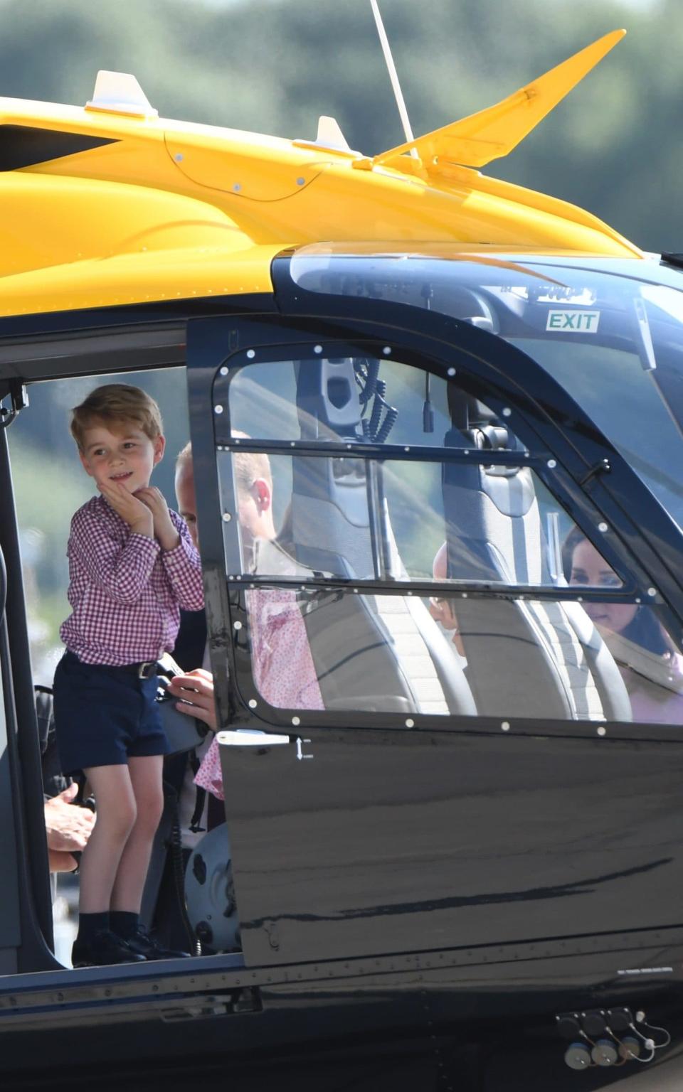 Prince George looked delighted as he explored a helicopter in Germany the day before his fourth birthday - Credit: PATRIK STOLLARZ