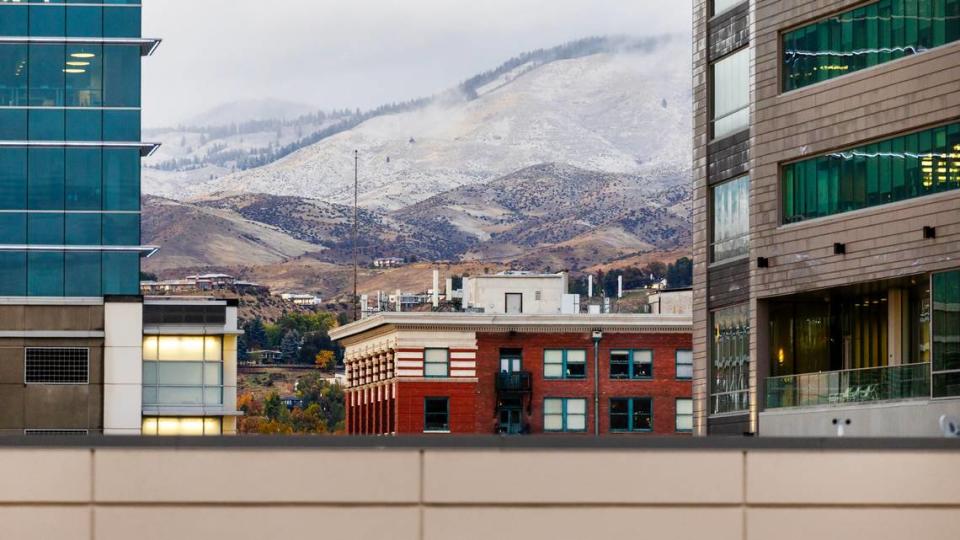 A wintry mix of precipitation falls in downtown Boise with light snow dusting the Foothills at higher elevation on Oct. 25, 2023.