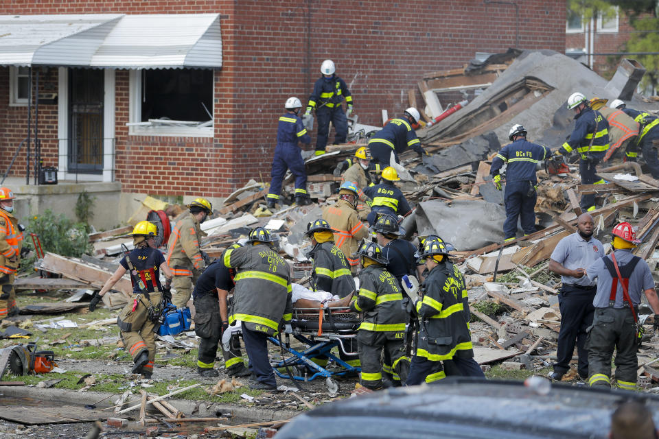 Baltimore City Fire Department carries a person out from the debris after an explosion in Baltimore on Monday, Aug. 10, 2020. Baltimore firefighters say an explosion has levelled several homes in the city. (AP Photo/Julio Cortez)