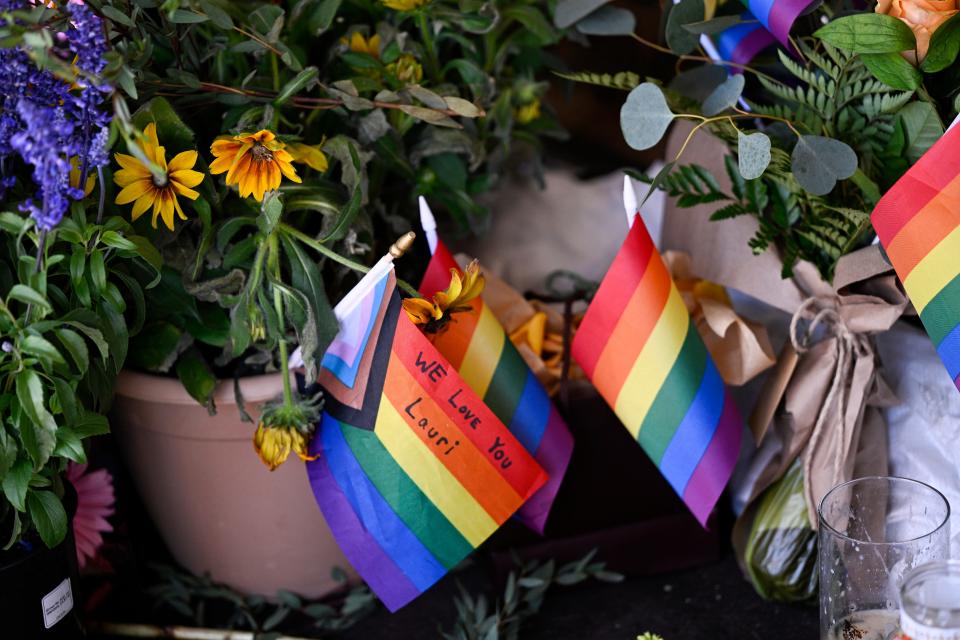 Rows of flowers and pride flags cover the Mag Pi storefront window as a memorial for store owner Laura Ann “Lauri” Carleton on Tuesday, Aug. 22, 2023, in Cedar Glen.