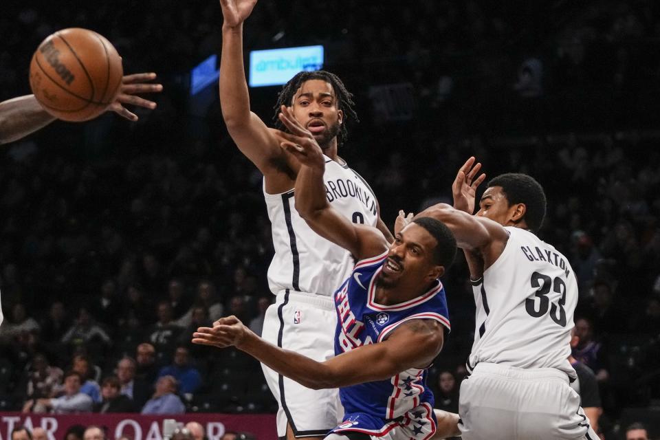 Philadelphia 76ers' De'Anthony Melton, center, passes the ball away from Brooklyn Nets' Trendon Watford, left, and Nic Claxton, right, during the first half of a preseason NBA basketball game Monday, Oct. 16, 2023, in New York. (AP Photo/Frank Franklin II)