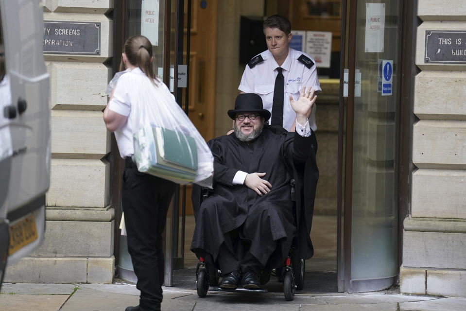Nicholas Rossi from he U.S. waves as he leaves the Edinburgh Sheriff and Justice of the Peace Court in Edinburgh, Scotland, Wednesday, July 12, 2023. An American fugitive accused of faking his own death to avoid a rape charge has been ordered by a judge in Scotland to be returned to the U.S. The man known as Nicholas Rossi was ordered extradited Wednesday after fighting the case for nearly two years. (Andrew Milligan/PA via AP)