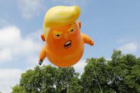 <p>A giant balloon inflated by activists depicting President Donald Trump as an orange baby is seen during a demonstration against Trump’s visit to the UK in Parliament Square in London on July 13, 2018. (Photo: Tolga Akmen/AFP/Getty Images) </p>