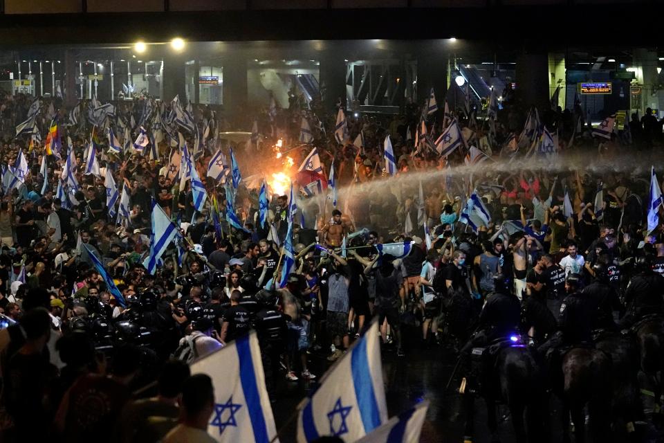 Riot police tries to clear demonstrators with a water canon during a protest against plans by Netanyahu's government to overhaul the judicial system, in Tel Aviv, Monday, July 24, 2023.