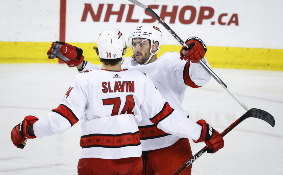 Carolina Hurricanes forward Stefan Noesen, right, celebrates after his goal with defenseman Jaccob Slavin, left, during first-period NHL hockey game action in Calgary, Alberta, Thursday, Dec. 7, 2023. (Jeff McIntosh/The Canadian Press via AP)
