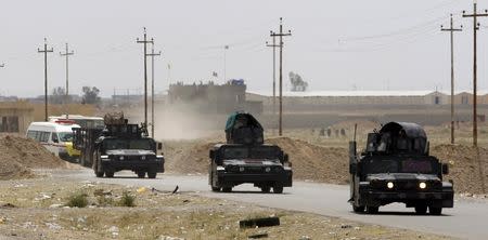 Military vehicles of Iraqi security forces are seen in Tikrit March 28, 2015. REUTERS/Thaier Al-Sudani