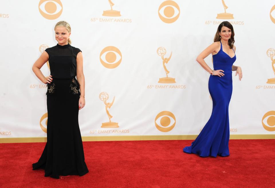 Amy Poehler, wearing Brian Rennie for Basler, left, and Tina Fey, wearing Narciso Rodriguez, arrive at the 65th Primetime Emmy Awards at Nokia Theatre on Sunday Sept. 22, 2013, in Los Angeles. (Photo by Jordan Strauss/Invision/AP)