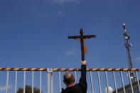 A protestor holds a cross, outside Cyprus' national broadcasting building, during a protest, in capital Nicosia, Cyprus, Saturday, March 6, 2021. The Orthodox Church of Cyprus is calling for the withdrawal of the country’s controversial entry into this year’s Eurovision song context titled “El Diablo”, charging that the song makes an international mockery of country’s moral foundations by advocating “our surrender to the devil and promoting his worship.” (AP Photo/Petros Karadjias)