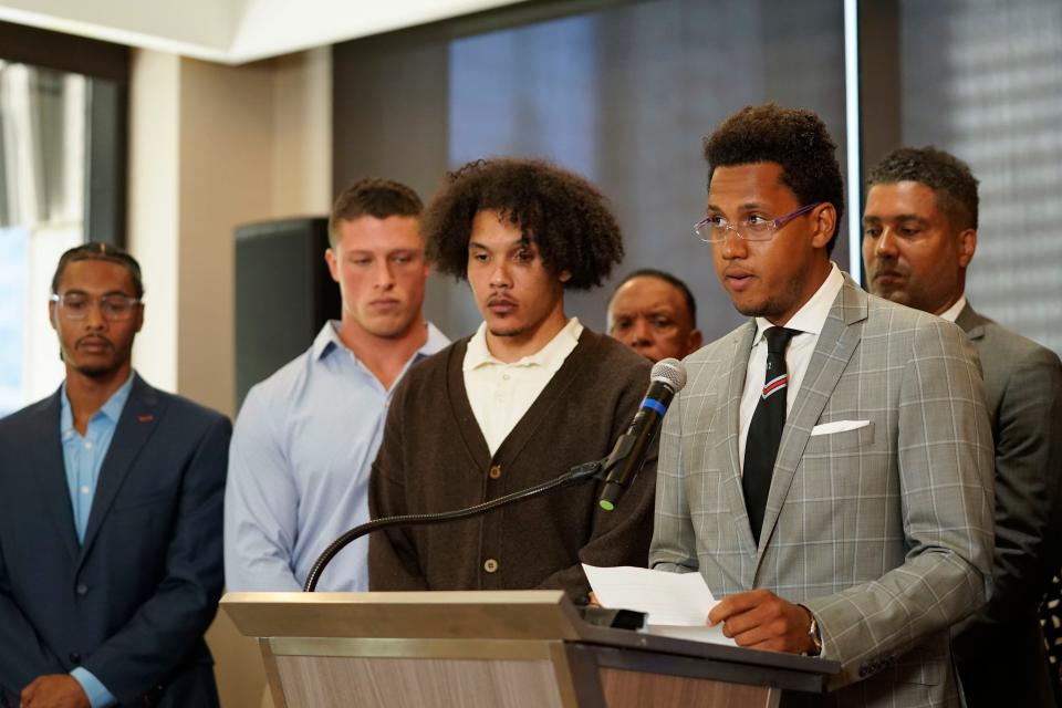 Standing with other former Northwestern University athletes, Lloyd Yates, right, speaks during a press conference addressing widespread hazing accusations at the school.