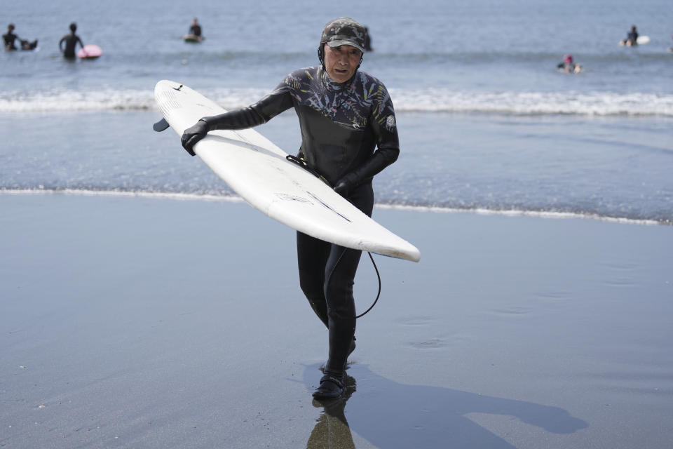 Seiichi Sano, an 89-year-old Japanese man, holds a surf board after riding waves at Katase Nishihama Beach, Thursday, March 30, 2023, in Fujisawa, south of Tokyo. Sano, who turns 90 later this year, has been recognized by the Guinness World Records as the oldest male to surf. (AP Photo/Eugene Hoshiko)