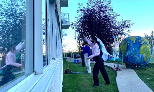 Sum Theatre group performed their show Through the Window outside a long-term care home in Regina on Thursday. (Ricardo Alvarado - image credit)