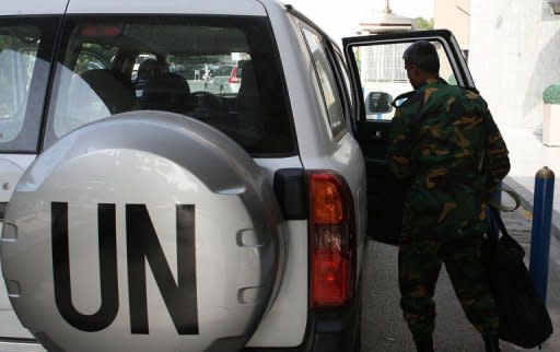 A member of the United Nations observer team readies to get into a vehicle outside their hotel in Damascus. UN observers suspended their operations in Syria on Saturday, blaming intensifying violence as troops rained shells down on rebel bastions including Homs where the opposition warned a massacre was looming