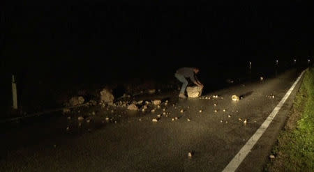 Still image from video shows a man trying to remove rubble from a road after an earthquake in Visso, Italy October 26, 2016. REUTERS/Reuters Tv