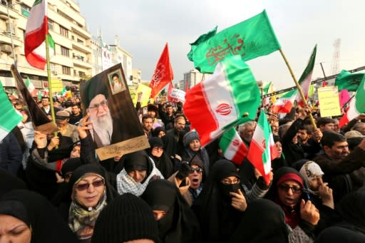 Iranian pro-government demonstrators raise national flags and pictures of the Islamic republic's supreme leader, Ayatollah Ali Khamenei, as they gather in the capital Tehran's central Enghelab Square