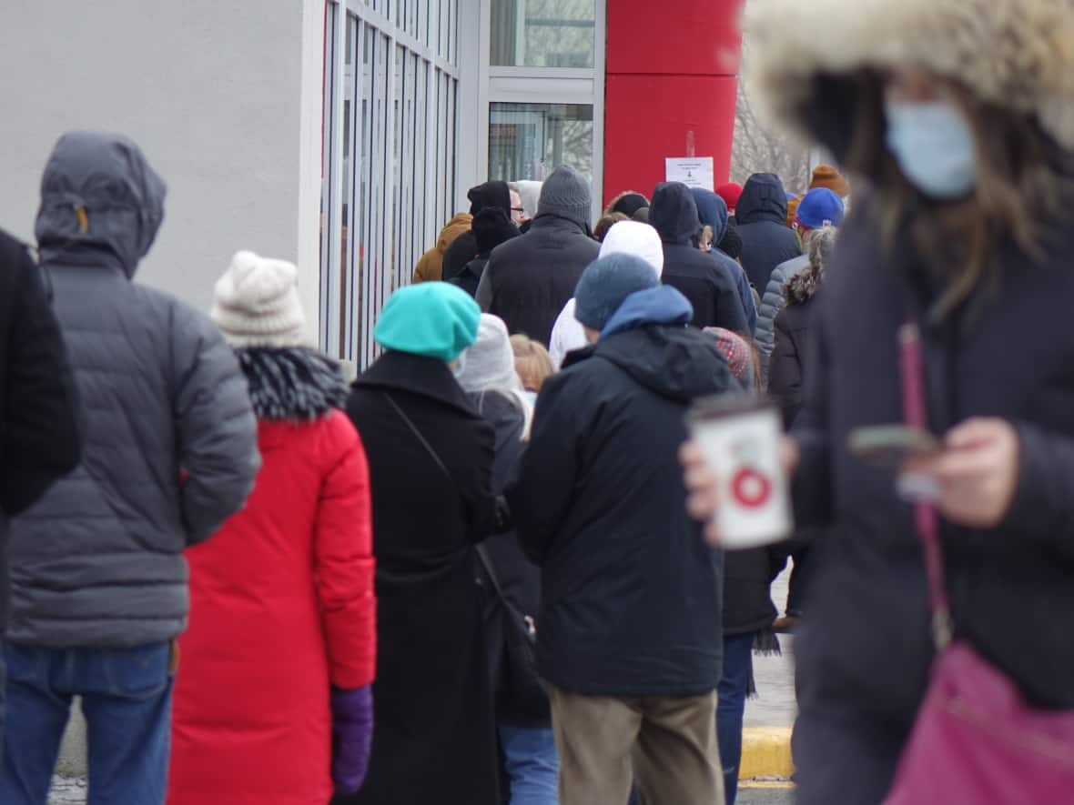 A long lineup outside a Shoppers Drug Mart in St. John's as people wait to get their COVID-19 booster shot.  (Patrick Butler/Radio-Canada - image credit)
